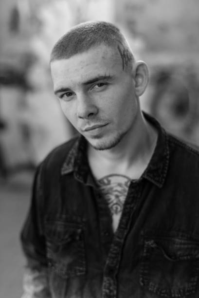 istock Young guy bully in black shirt. Black and white photo. BW 1265690070
