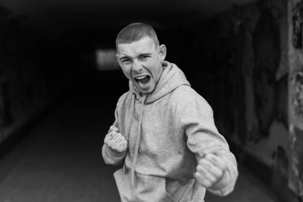 un gars tyran dans une veste de sport légère avec une capuche. photo en noir et blanc. bw - hooded shirt men macho hood photos et images de collection