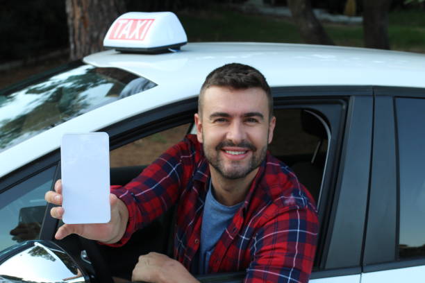 istock Taxi driver showing app in smartphone 1265690262