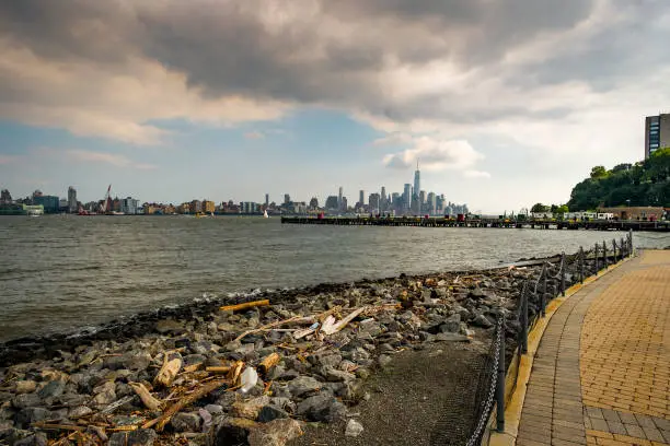 Debris and litter on the coast of NJ with New York City skyline in the background