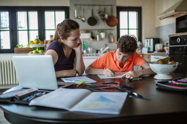 istock Mother helping son with homework at home 1265692336
