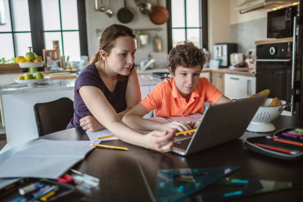 istock Mother helping son with homework at home 1265694215