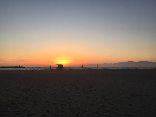 istock Landscape view of sandy beach sunset with distant coastline at sunset 1265695189