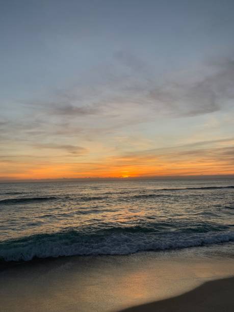 istock Vibrant sunset over calm sandy beach shoreline 1265700031