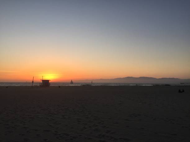 istock Landscape view of sandy beach sunset with distant coastline at sunset 1265701954