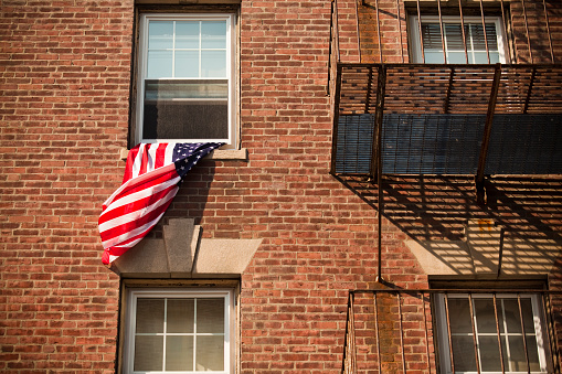 American flag flying from an apartment on the 4th of July