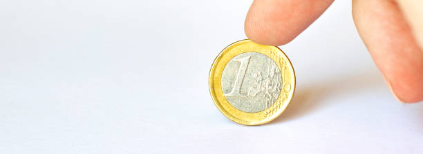 istock Man hand holding coin isolated on white background with clipping path. 1265704464