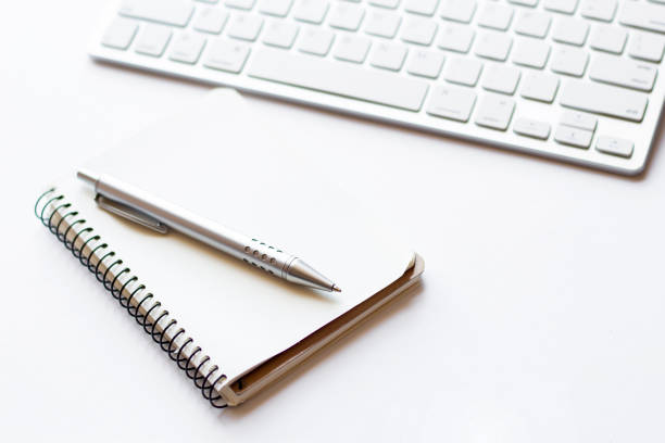 istock Notepad, keyboard and pen isolated on white background, business concept 1265704483