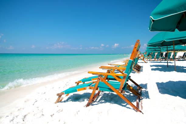 Summer Adirondack Beach Chairs in the Tropics Sunny Adirondak beach chairs with umbrellas in the sand and surf gulf of mexico photos stock pictures, royalty-free photos & images