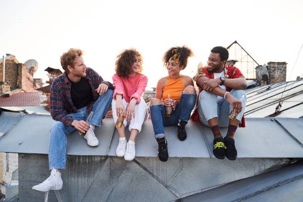 istock Four young people spending summer evening on roof 1265724365