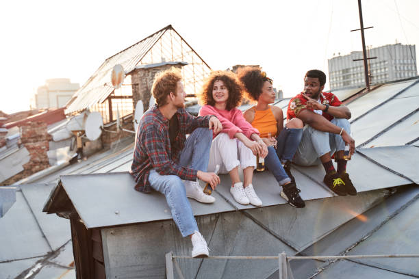 istock Happy friends relaxing with beer on roof 1265724370