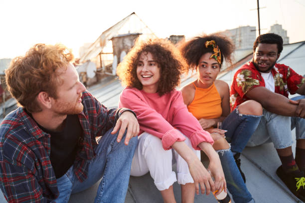 istock Two happy couples meeting sunset on roof 1265724373