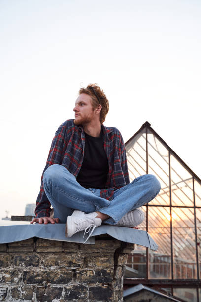 istock Serene handsome man relaxing at dawn on roof 1265726006