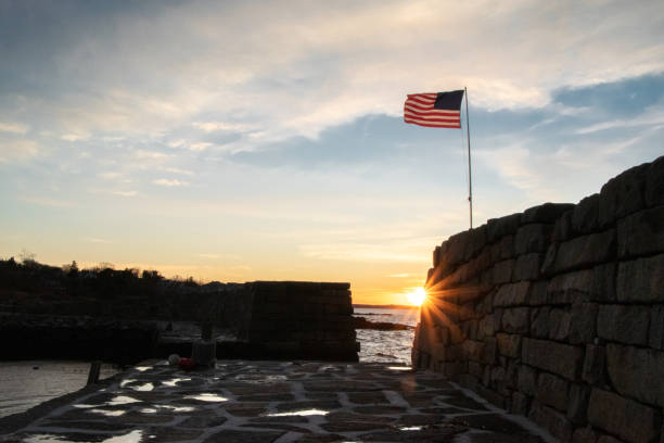 istock American Flag on Sea Wall at Sunset 1265732712