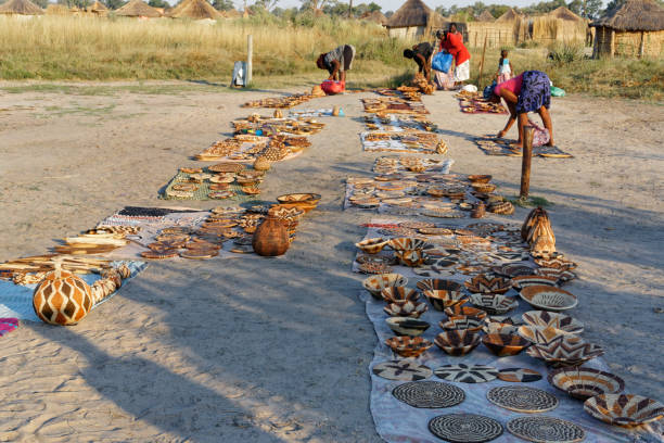 senhoras da aldeia montando um mercado de cestas., okavango delta, botsuana, áfrica. - makoro - fotografias e filmes do acervo