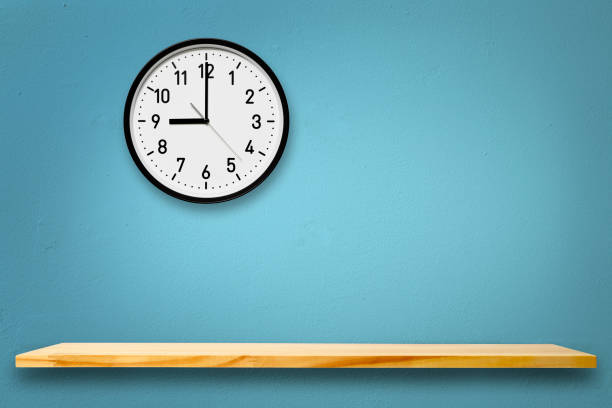 Wall clock above the wooden shelf