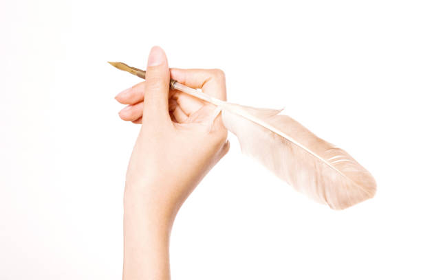 istock woman hand hold a feather fountain pen horizontal isolated on white. 1265798433