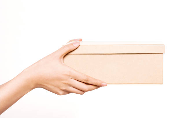 istock woman hand hold a craft box closed isolated on white. 1265798494
