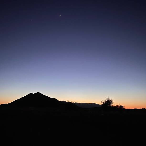 Sunset over the desert with stars stock photo