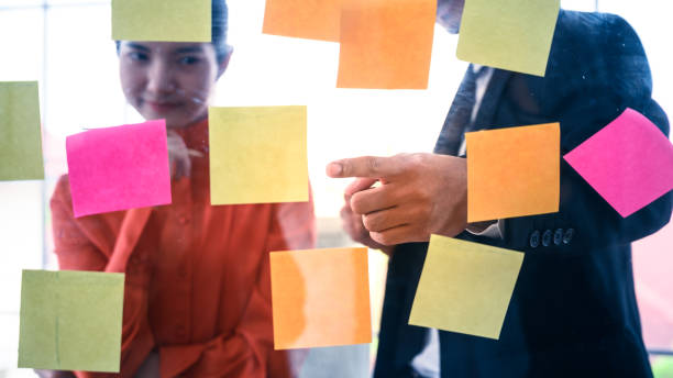istock Business couple   meeting at office and use post it notes to share idea. 1265815805