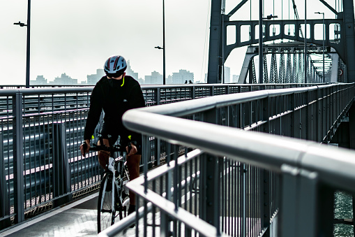 Florianopolis, Santa Catarina, Brazil. August 8, 2020:A cyclist passing through the metal bridge, in the new normal.