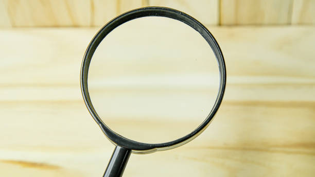 istock a  Magnifying glass on wood background image. 1265829795