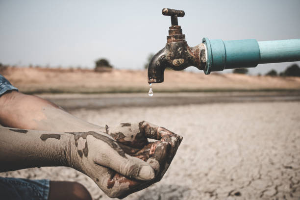 istock The little boy waiting for drinking water to live through this drought, Concept drought and crisis environment. 1265846929