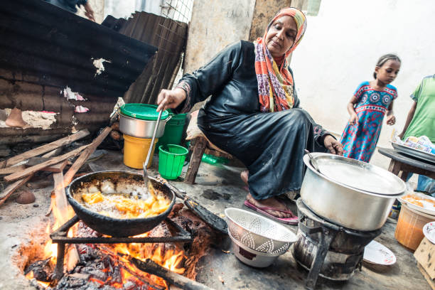 muzułmańska kobieta z abaya i kolorowym hidżabem smażenia frytek z ogniem na patelni - pan frying pan fire fried zdjęcia i obrazy z banku zdjęć