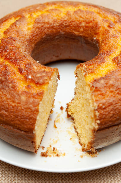 istock Cornmeal Cake (Bolo de Fuba) cut Brazilian style on a white plate. Isolated on jute. Front view. Close-up. Vertical shot 1265906884