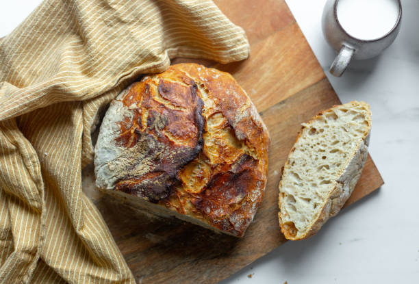 istock fresh artisan bread on wood tray over marble table with copy space 1265912130