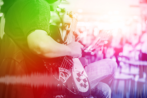 musician guitarist with overlay colorful effect for music entertainment event on stage show background.