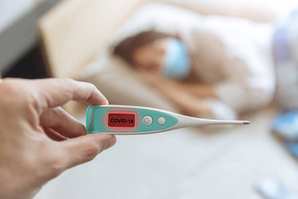 istock closeup hand show Coronavirus flu detector device display show results and identify Covid-19 patients 1265915637