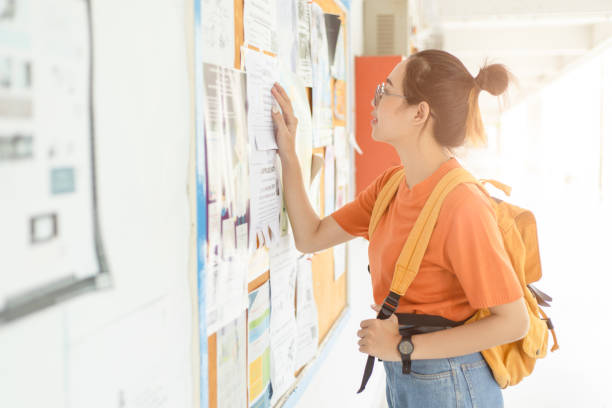 mujer universitaria joven desempleada en busca de trabajo o trabajo después de graduarse en la junta de correos - job search recruitment occupation employment issues fotografías e imágenes de stock