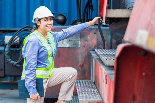 asiatische junge teen glücklich lächeln ingenieur arbeit mit schwerindustrie maschine mit sicherheitsanzug und hardhat, aussehen kamera. - harbor commercial dock engineer service stock-fotos und bilder