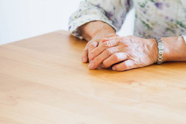 Older woman's hands with crossed fingers in resting and relaxed attitude.