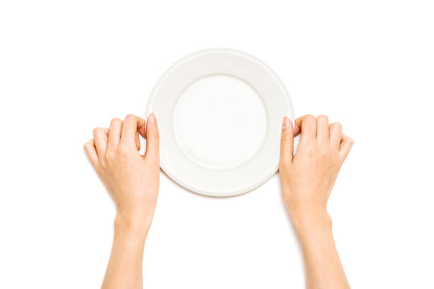 istock Woman hand hold a white ceramic dish isolated on white. 1265927664