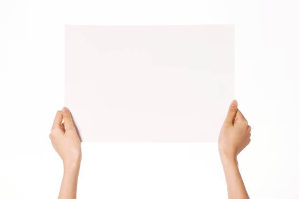 istock Woman hand hold a blank paper isolated on white. 1265928179