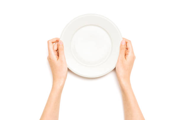 istock Woman hand hold a white ceramic dish isolated on white. 1265928182