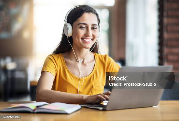 Smiling Arab Girl With Headset Studying Online Using Laptop Stock Photo - Download Image Now