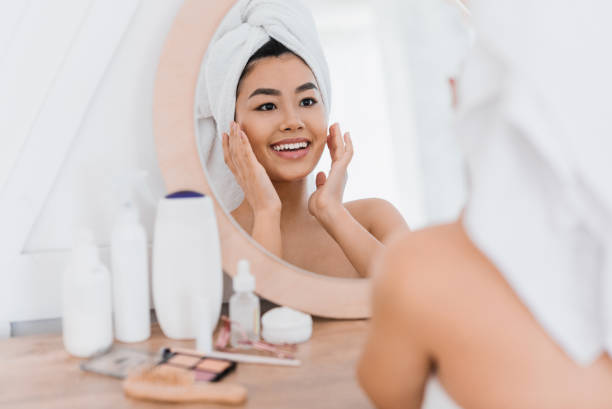 istock Pretty asian girl applying cream on her face 1265928189