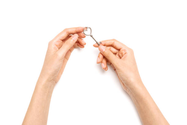 istock Woman hand hold a vintage key isolated on white. 1265928773