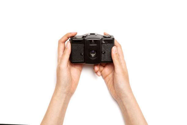 istock Woman hand hold a vintage camera isolated on white. 1265929297