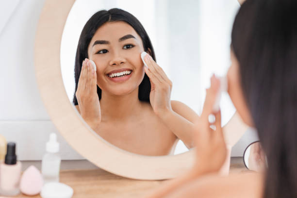 istock Cheerful asian girl cleaning her face, using cotton pads 1265936933