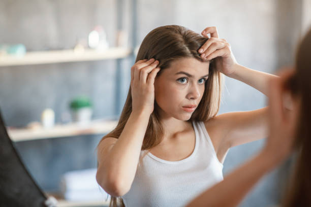 chica bonita con problema de pérdida de cabello mirando en el espejo en casa - cabello humano fotografías e imágenes de stock