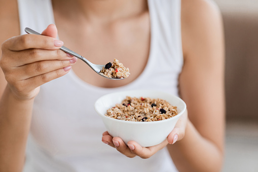 Cropped image of woman holding bowl with homemade granola or oatmeal