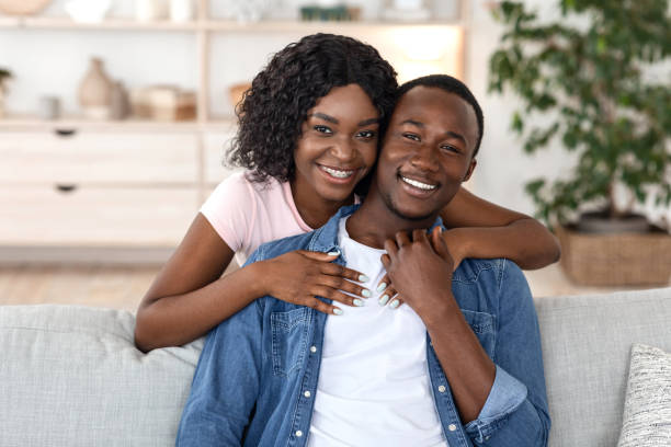 istock Cheerful african woman hugging her husband from behind 1265941278