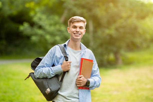 istock Portrait Of Handsome University Student Guy With Backpack And Workbooks Posing Outdoors 1265941423