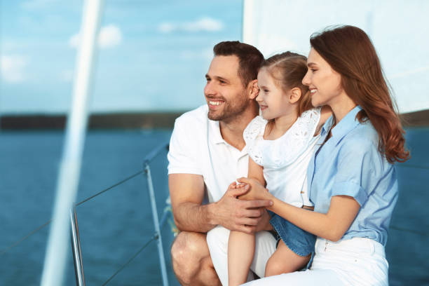 istock Family Yachting Sitting On Deck Looking Aside Enjoying Vacation 1265943387
