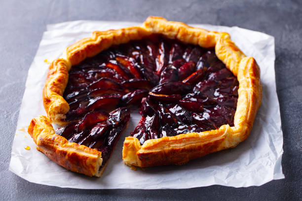 Plum galette, pie. Grey background. Close up.