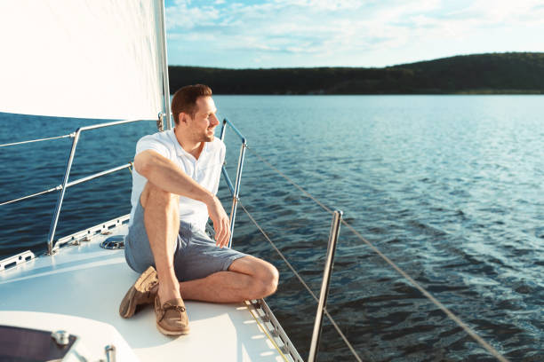 istock Man Relaxing Sitting On Sailboat Deck Spending Summer Day Outside 1265944620